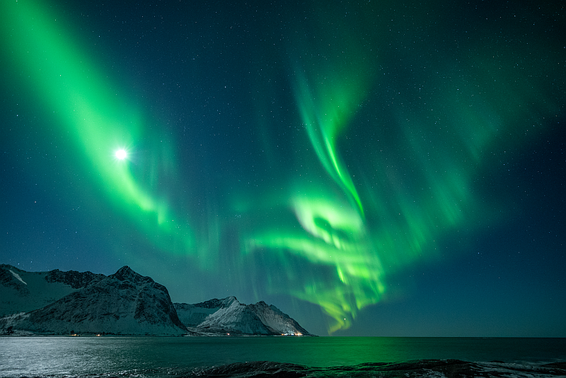 Vollmond mit Polarlichtern auf der Insel Senja